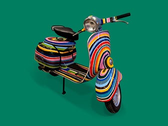 Multi-coloured scooter on green background