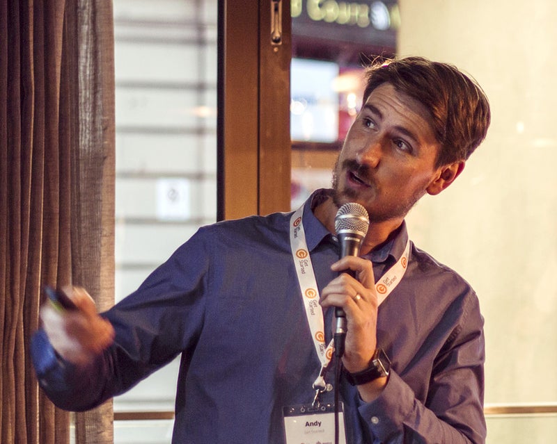 Man looking to the side and speaking into a microphone