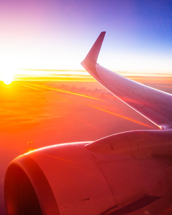 Plane wing with sunrise in the background
