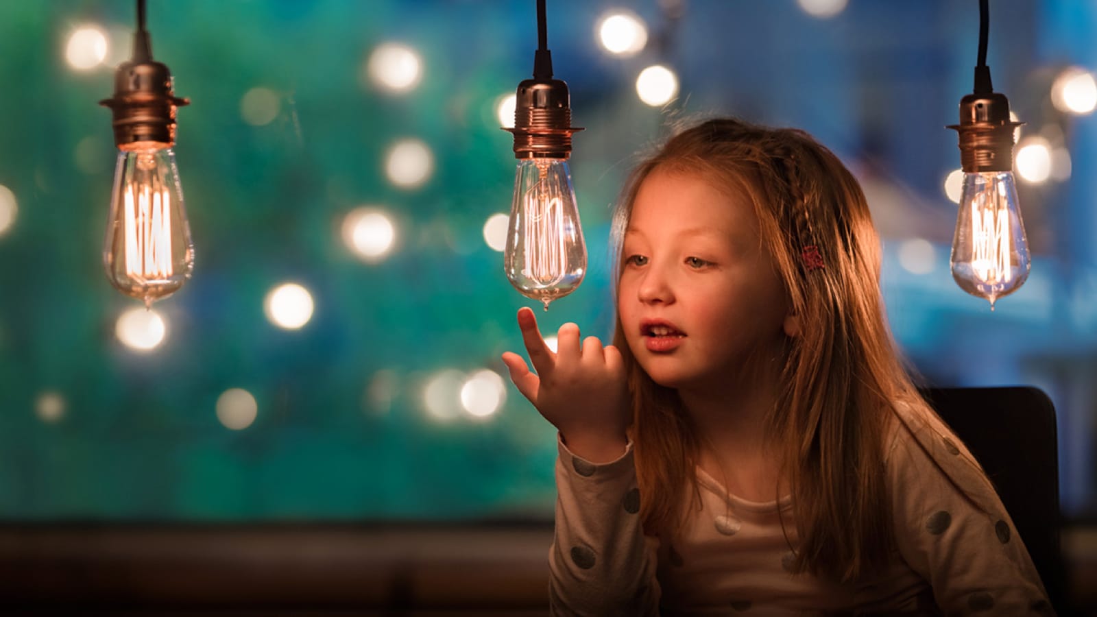 Young girl looking at light bulbs
