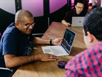 Man at a laptop looking at an Amazon Alexa