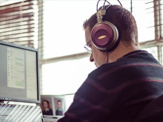 Man with headphone on working at a computer